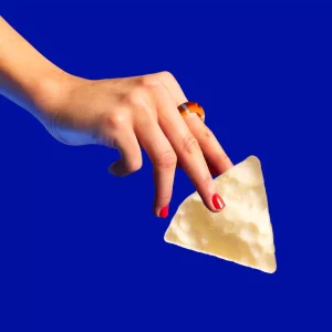 women hand holding Proper Chip in blue background